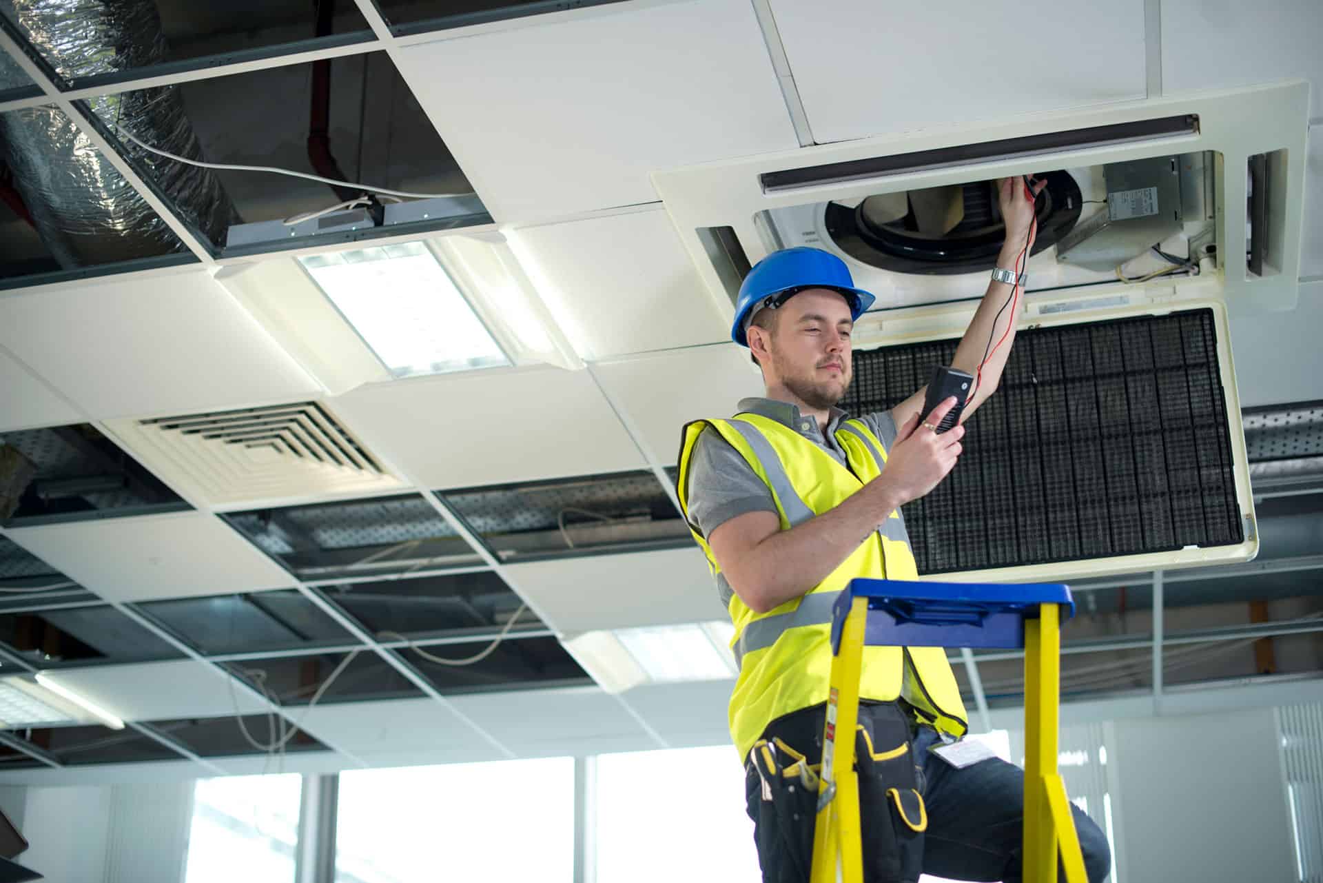 man servicing air conditioning unit