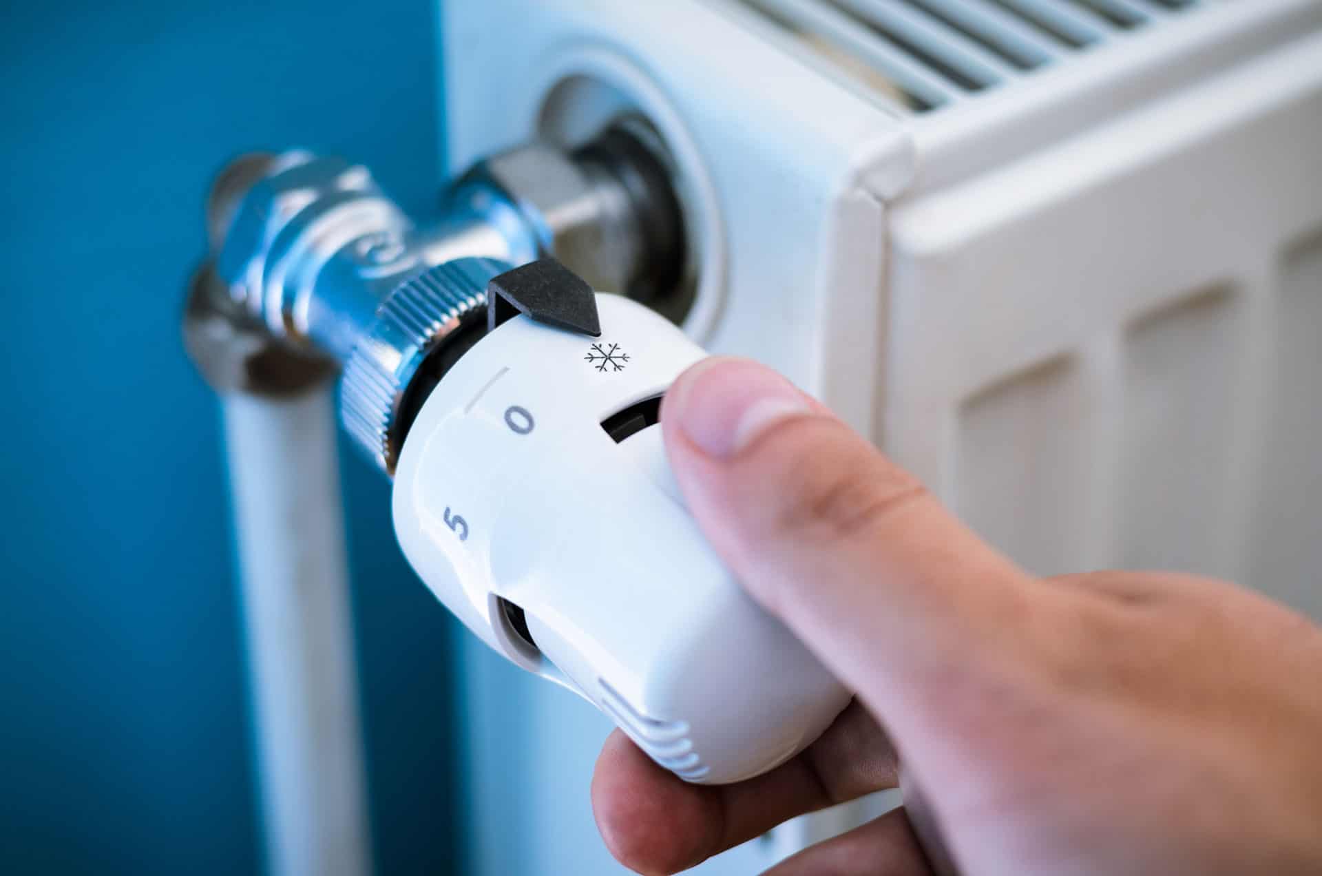 man adjusting radiator - heating and plumbing