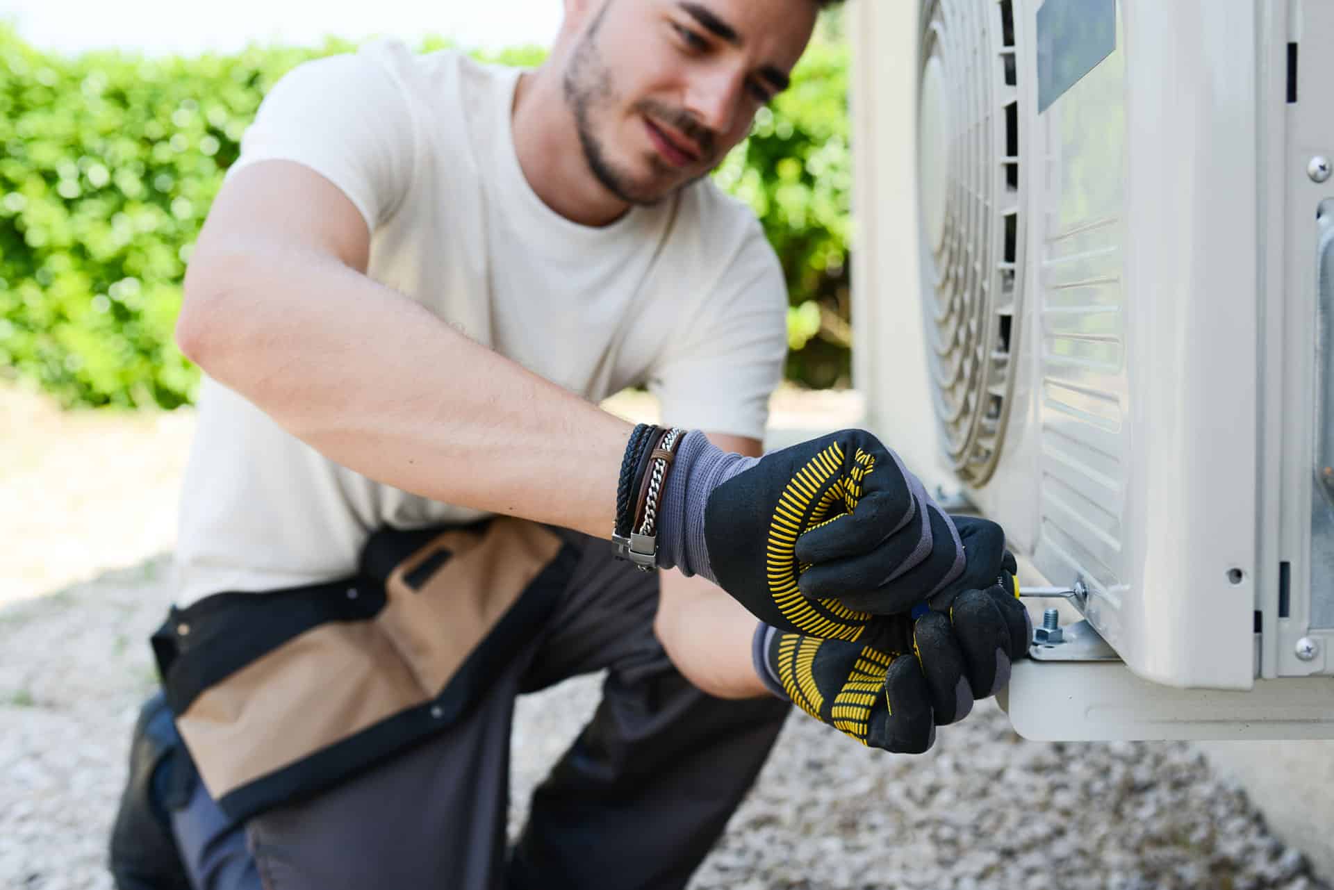 man adjusting air conditioning unit